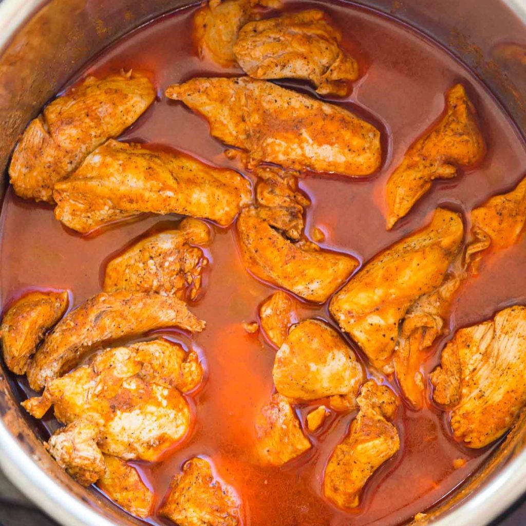 cooked chicken with homemade buffalo sauce in an instant pot