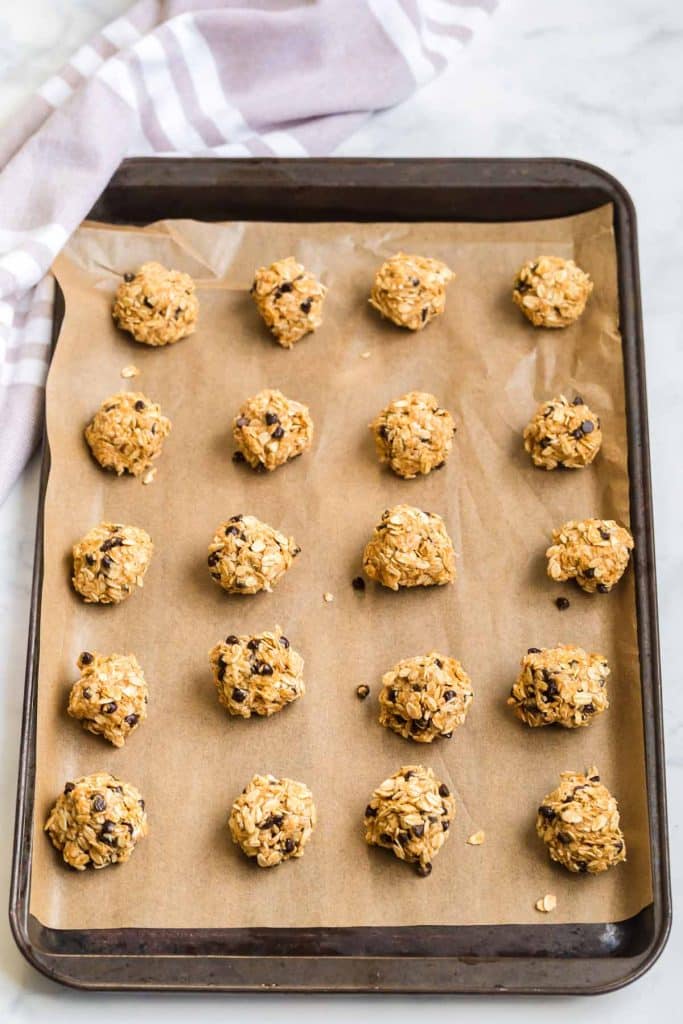 parchment lined baking sheet with peanut butter, oats and chocolate chip protein balls