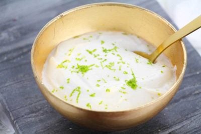 gold bowl filled with key lime wonder whip recipe. A gold spoon sits in bowl.