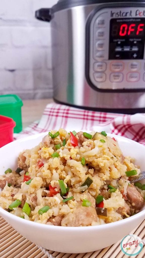 Cauliflower Chicken Fried Rice in a white bowl with no title or wording. Instant Pot and 21 Day Fix containers in the background out of focus. 