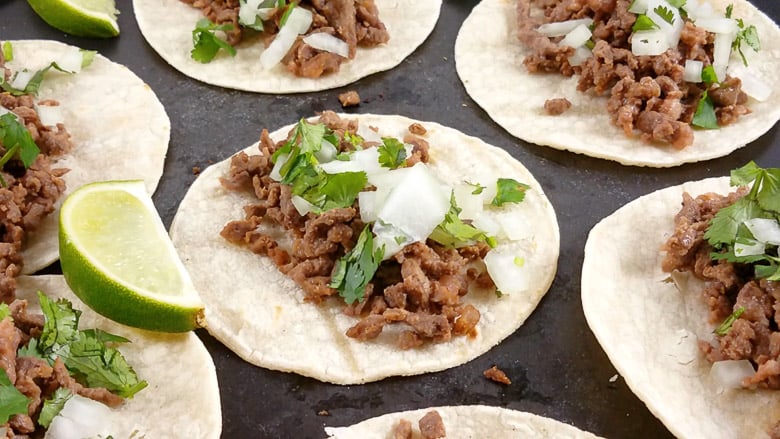 carne asada tacos on a black platter