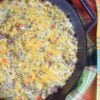 image of zucchini and sausage breakfast casserole in a skillet on a colored towel