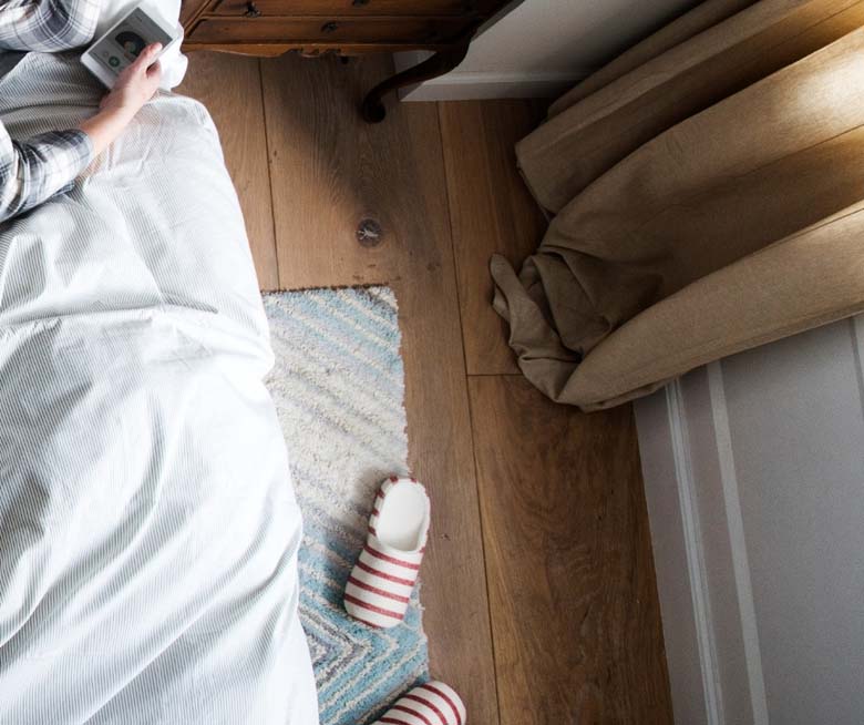 image of slippers next to a bed