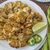 cauliflower steaks with lime and jalapeno on a white plate