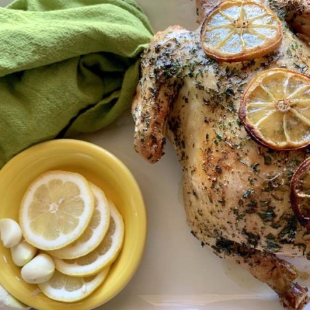 cooked rotisserie chicken on the grill on a white platter