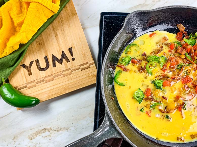 veggies and eggs cooking in a pan