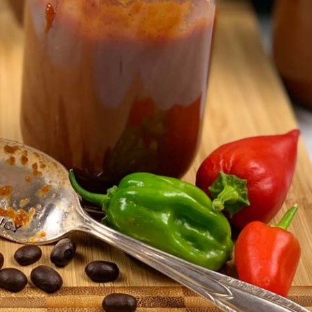 peppers, coffee beans, and bbq sauce on wood cutting board