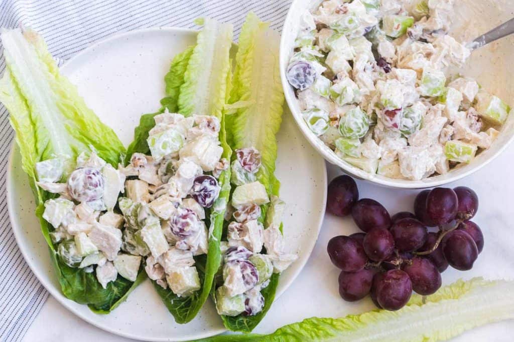 chicken salad lettuce wraps with bowl of chicken salad on white counter
