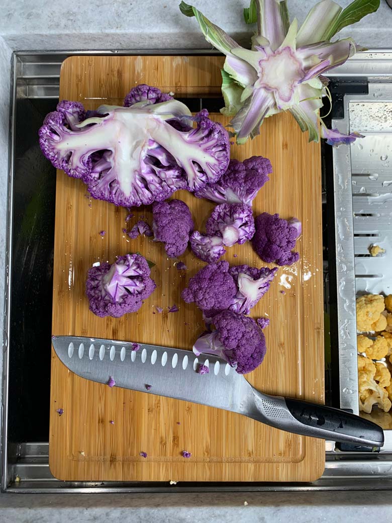 cut cauliflower on a wood cutting board