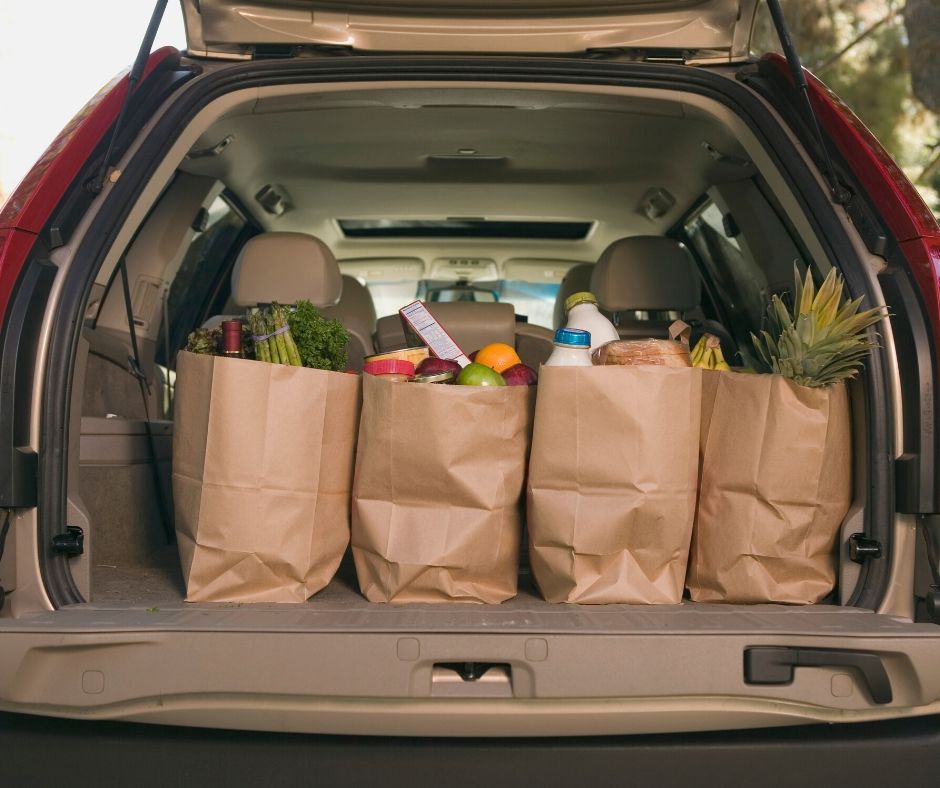 Groceries in bags in the back of the car.