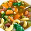 close up of minestrone soup in white bowl