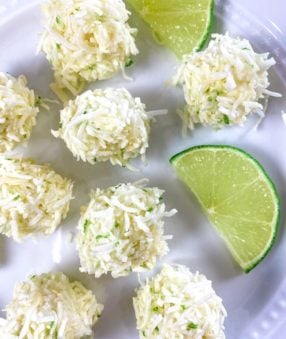 white plate with coconut bites and lime slices