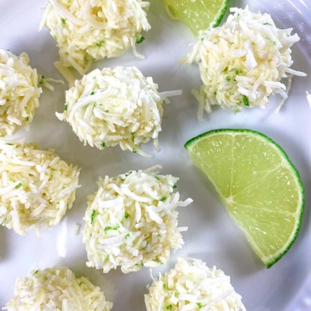 white plate with coconut bites and lime slices