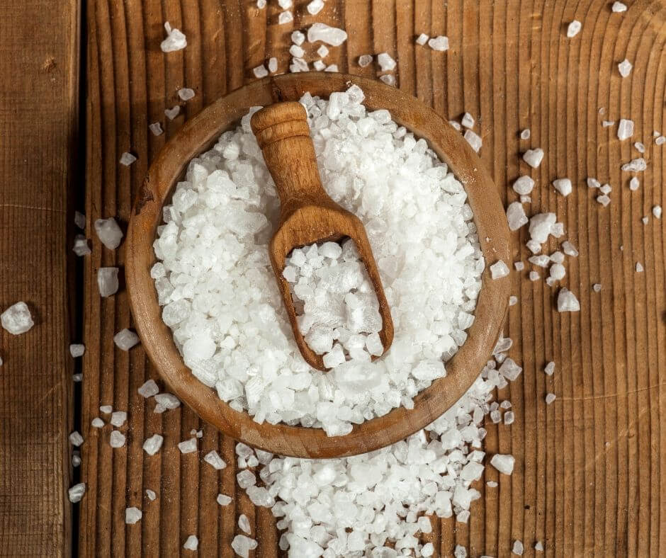 Salt on a wooden serving spoon for the post different types of salts.