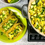 calabacitas and tacos on a green plate, garnished with jalapenos.