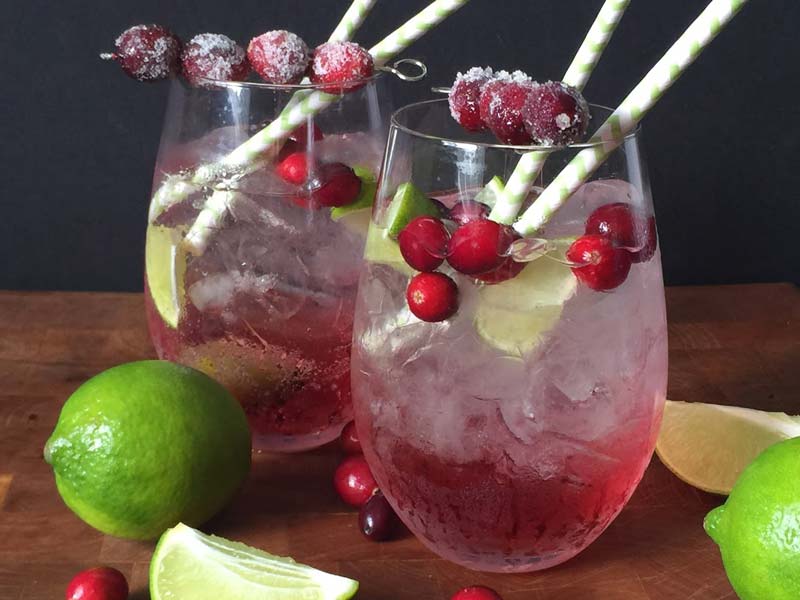 view of two cranberry margaritas in clear wine glass