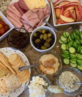 snacks and appetizers on a wood platter