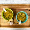 Blue and green bowl of miso soup on a cutting board