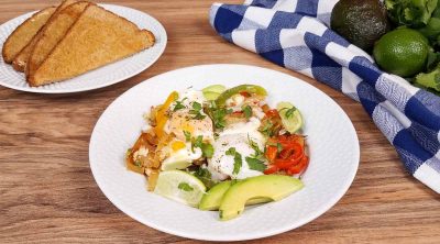 white plate with breakfast fajitas and a plate of toast in the background