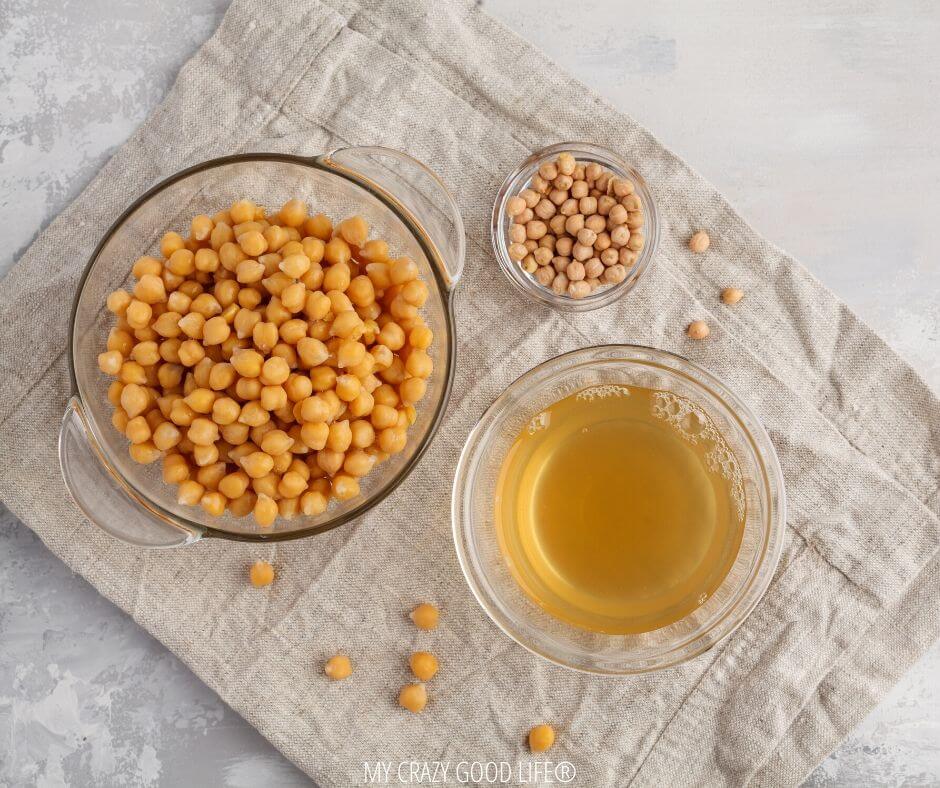 A top down view of the chickpeas in one bowl and their aquafaba in another bowl.