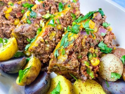 close up of sliced meatloaf with roasted potatoes