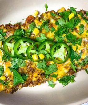 Overhead picture of Mexican meatloaf topped with jalapenos on a white plate