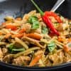 close up of cooked and plated drunken noodles in black matte bowl