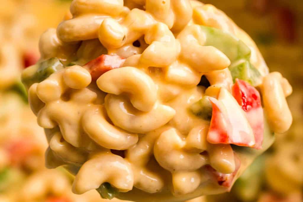 Close up of healthy mac and cheese with red and green bell peppers.