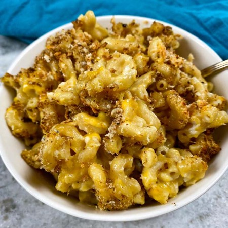 close up of mac and cheese with breadcrumbs in white bowl