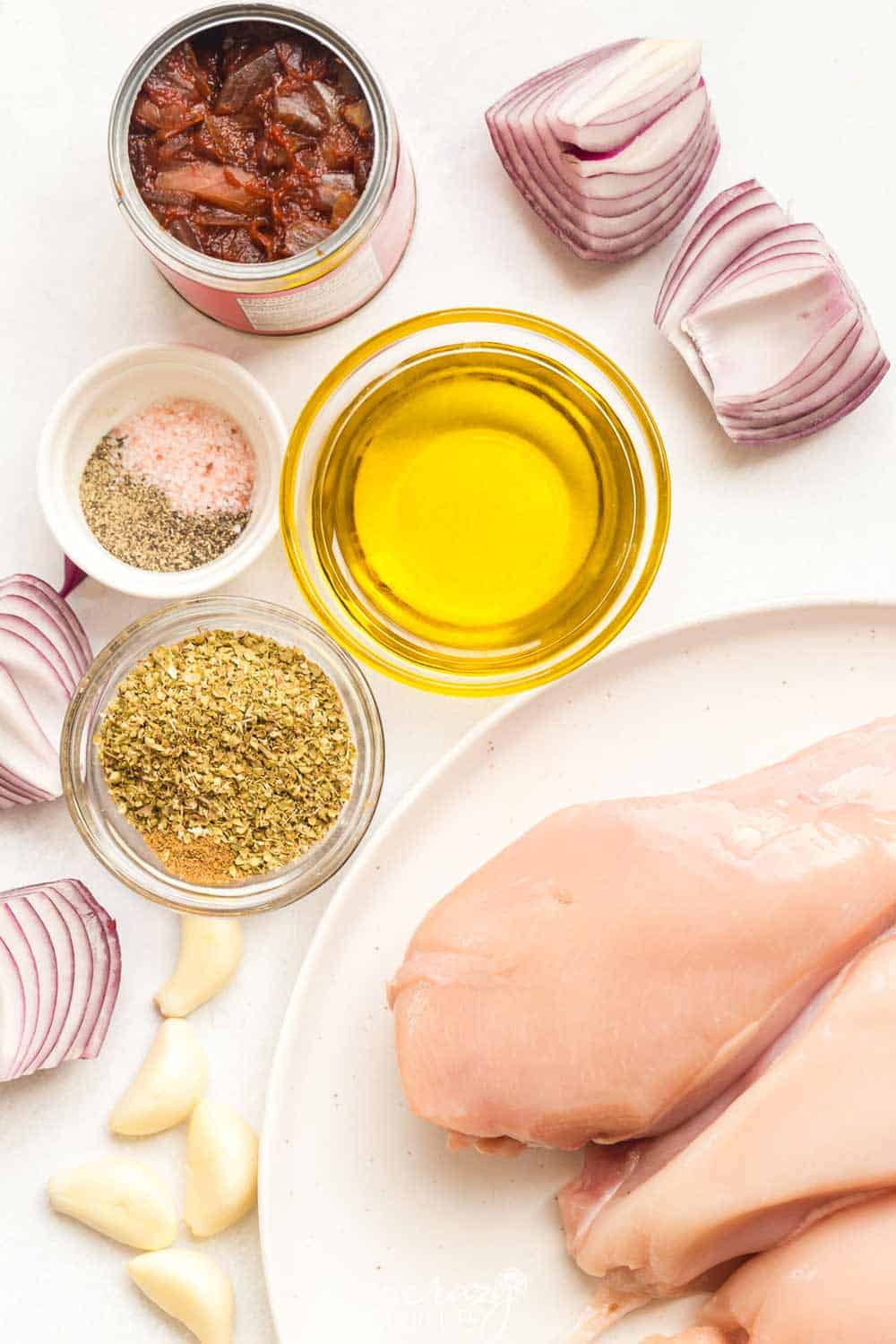 White and glass bowls of ingredients in copycat chipotle chicken marinade on a white counter.