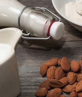 almonds and almond milk containing gellan gum, on table