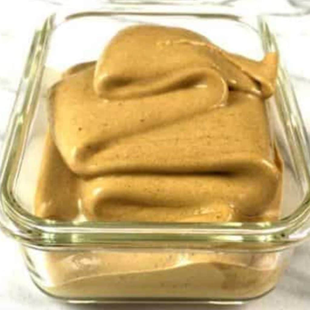 A glass rectangular dish with ice cream mixture that has just been poured in and is about to go in the freezer.