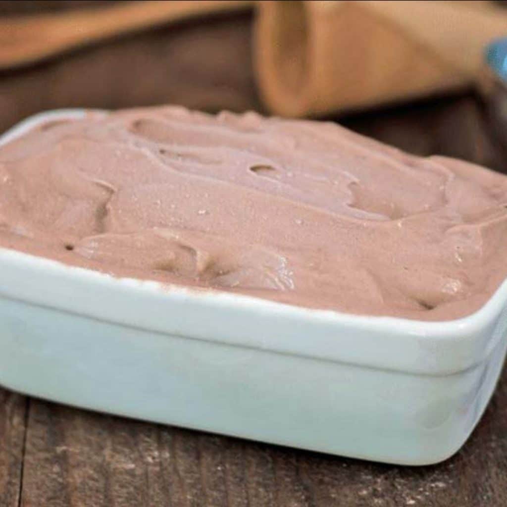 A white rectangular dish full of frozen chocolate banana ice cream.