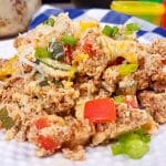 White plate with turkey chorizo and a fork. You can see red and green vegetables in the chorizo, with cheese on top.