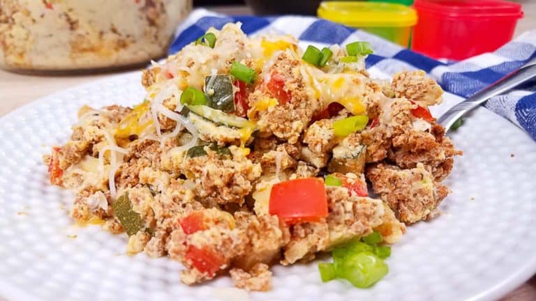 White plate with turkey chorizo and a fork. You can see red and green vegetables in the chorizo, with cheese on top.