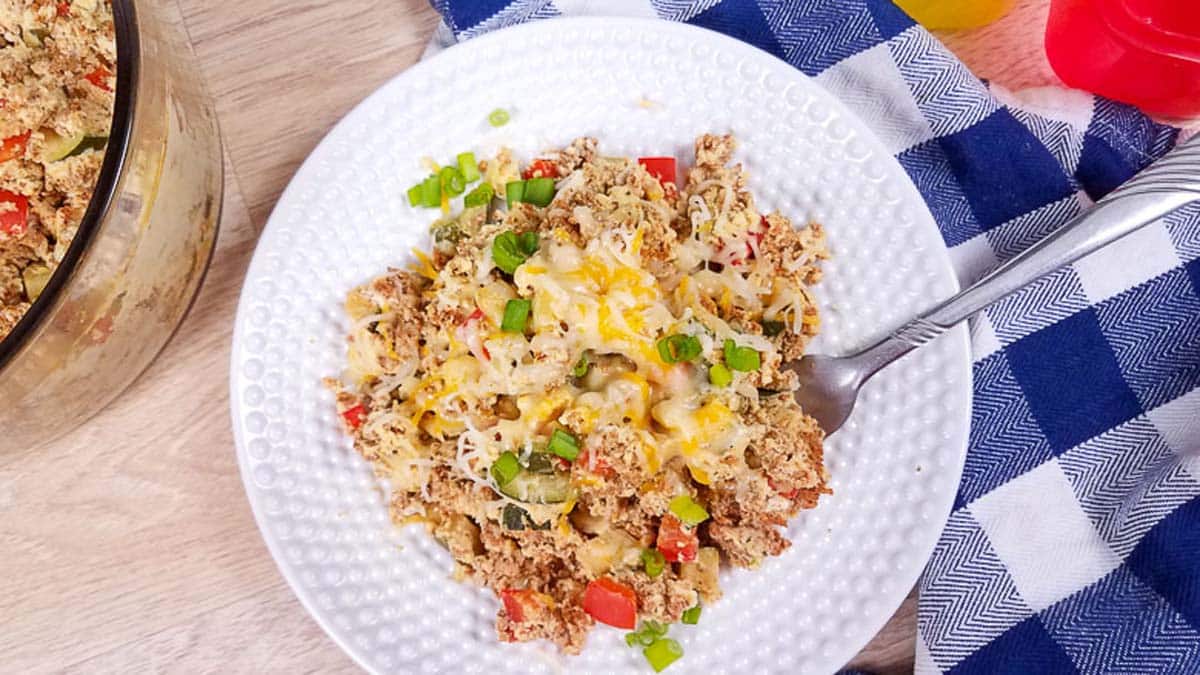 White plate with Turkey Chorizo and eggs. There is a blue and white checkered napkin in the background.
