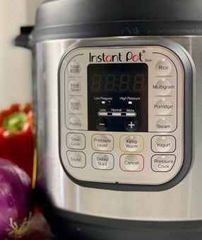 instant pot on the counter with vegetables around it