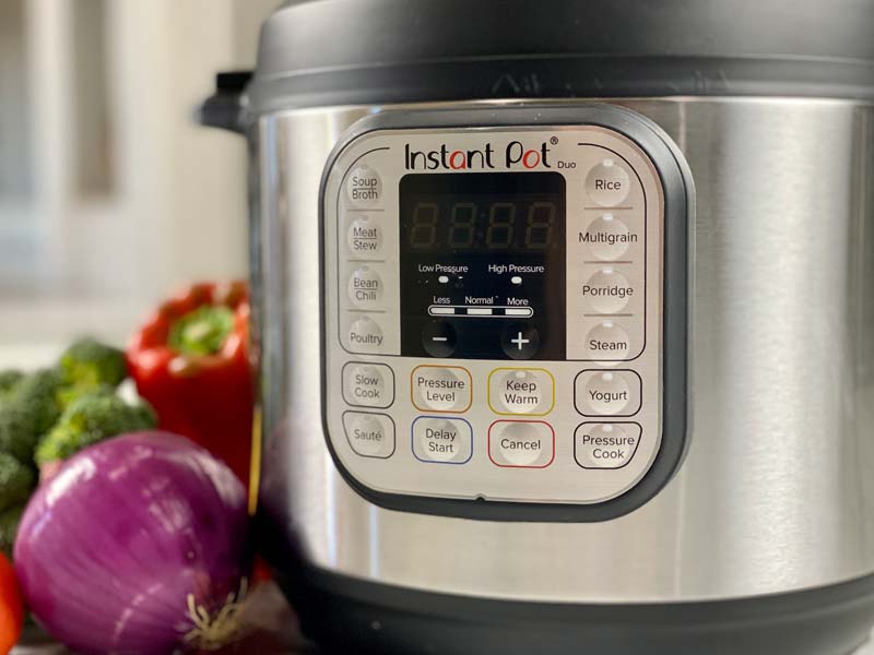 instant pot on the counter with vegetables around it