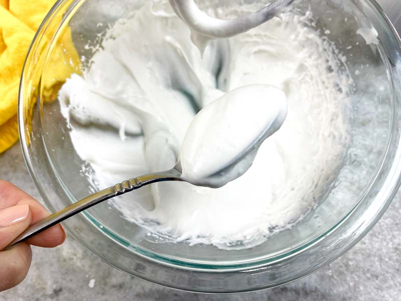 close up of coconut whipped cream on a spoon