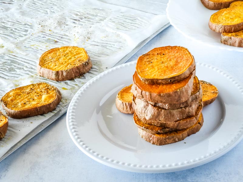 Stack of sweet potatoes on a white plate. 