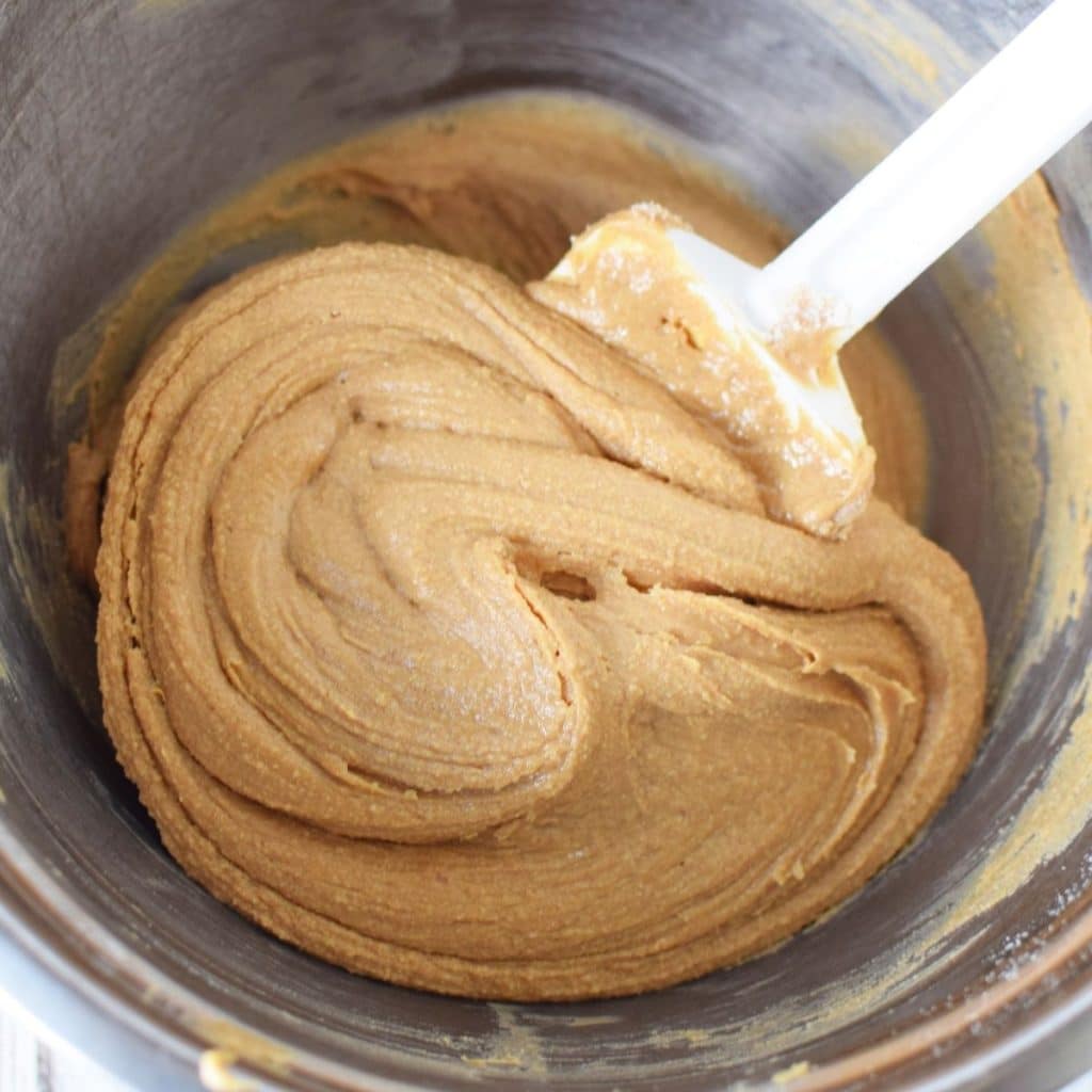 A stainless steel bowl with creamy peanut butter that has been stirred together wit flour and honey to create a luscious, smooth peanut butter for the center of a chocolate buckeye.
