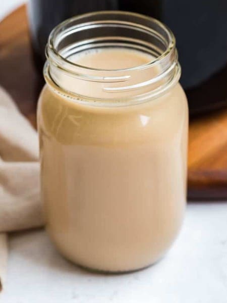 Mason jar with no lid, full of homemade vanilla coffee creamer.