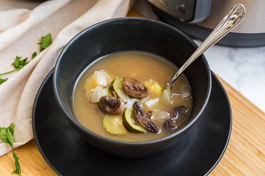 black bowl of Bone Broth Soup with spoon