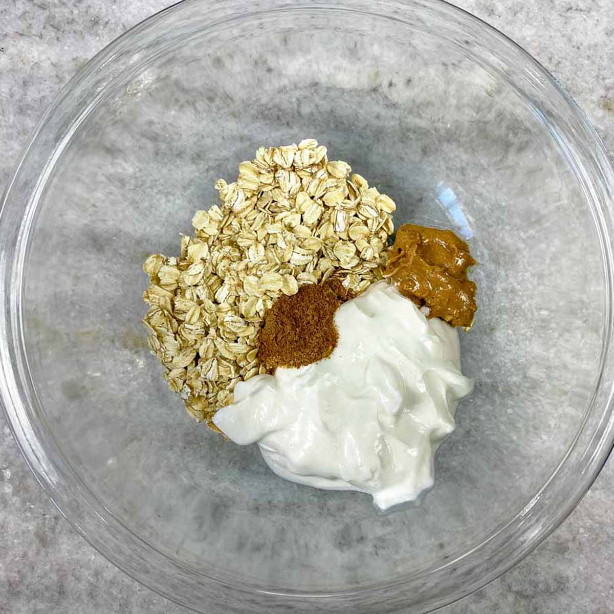 Glass bowl with ingredients for overnight oats.