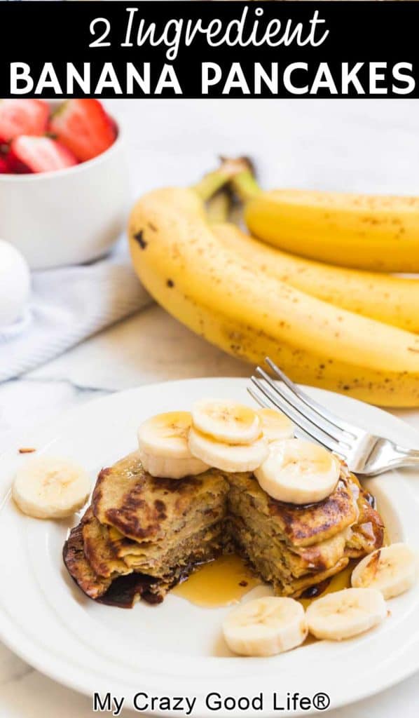 banana pancakes cut in center on a white plate with sliced bananas on top