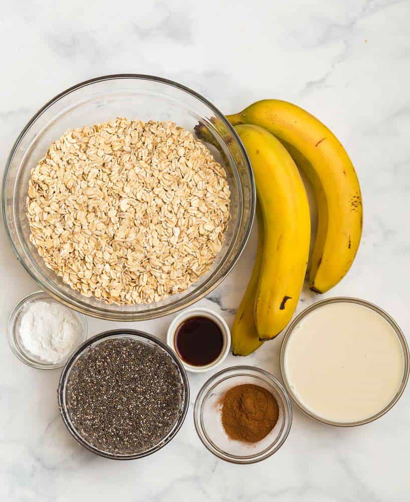 top down view of ingredients in baked banana oatmeal on a white marble counter