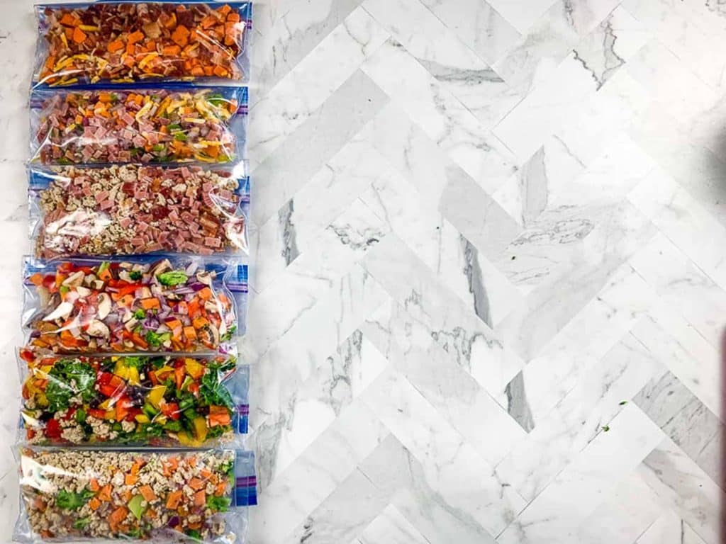 six plastic freezer bags full of different ingredients to make DIY Just Crack an Egg Cups