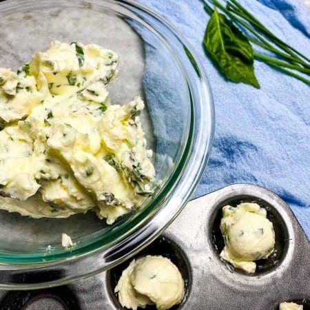 herb butter in bowl and scooped into muffin tin