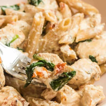 close up of bite of tuscan chicken on fork