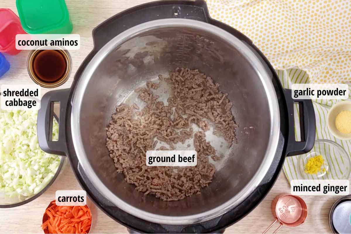 Open Instant pot with ground beef cooking, bowls of other ingredients for this recipe around the pot. 